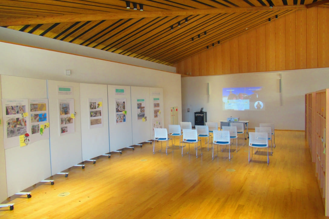 市民交流スペースに椅子が並びプロジェクターの映像を鑑賞する様子